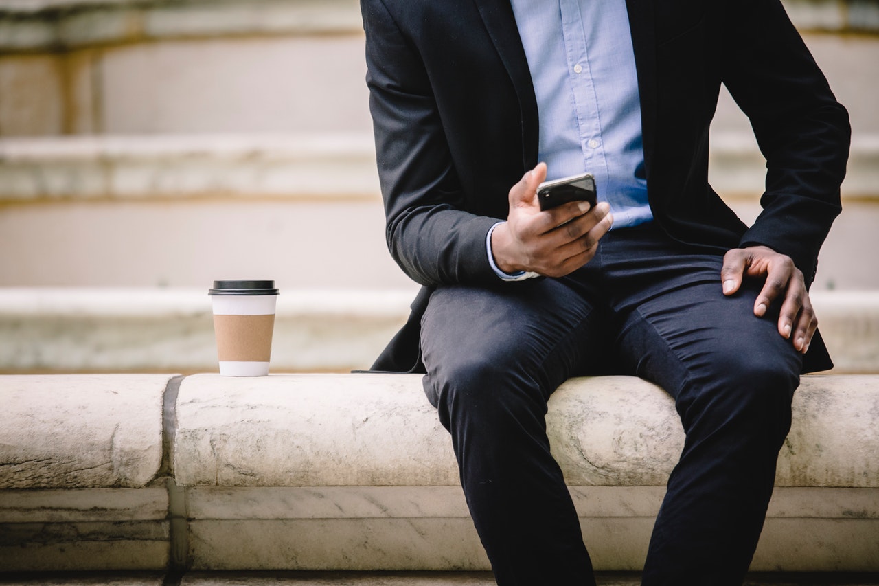 Man in suit using smartphone outside