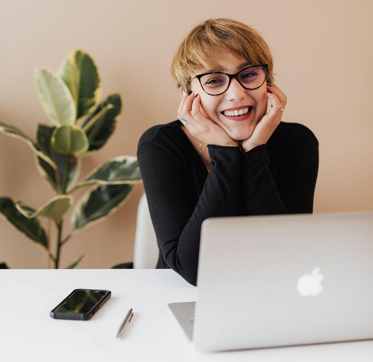 Happy woman holding her face in her hands because she was hired at insurance company