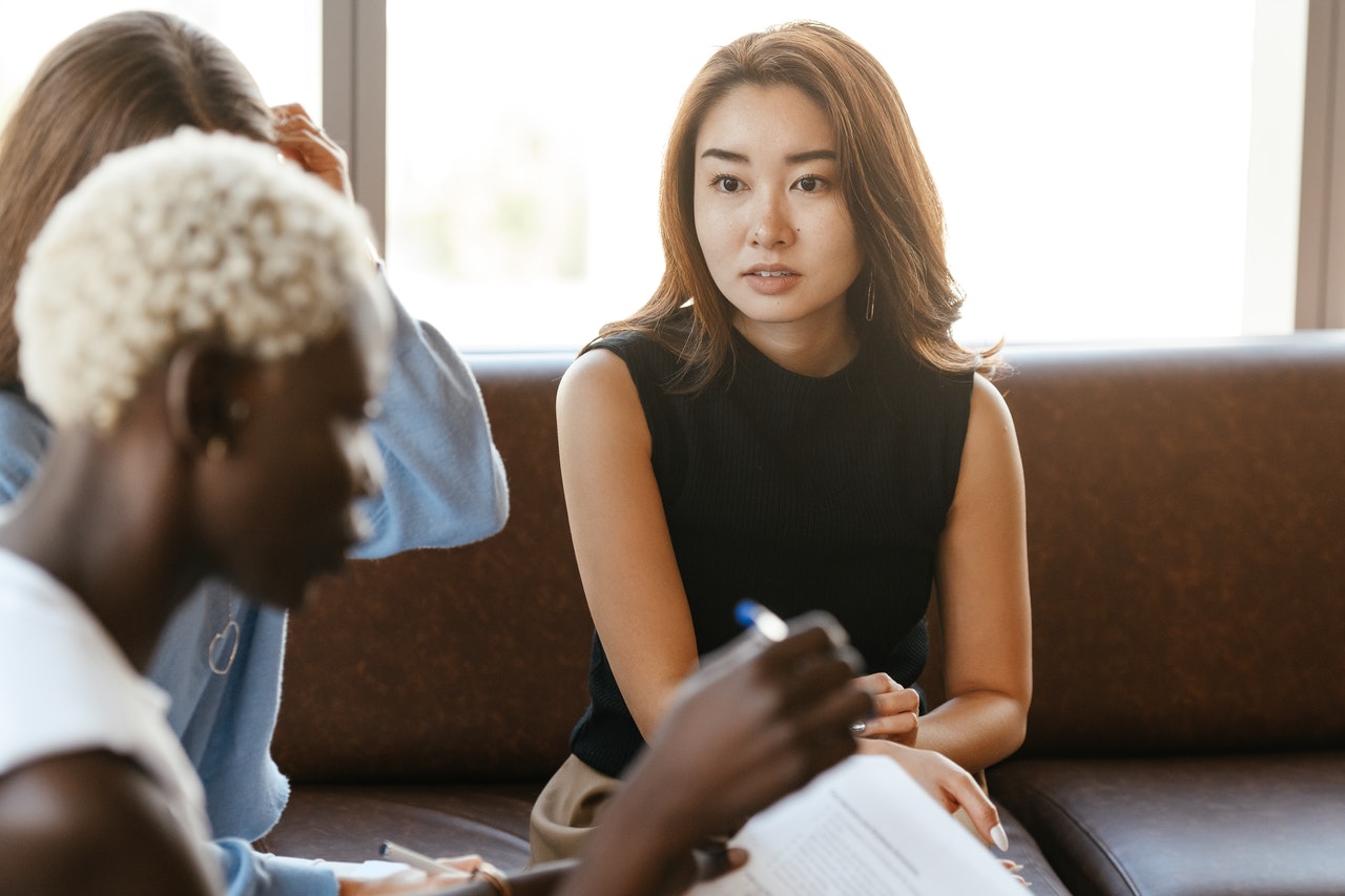 Three insurance workers discussing conflict with producer