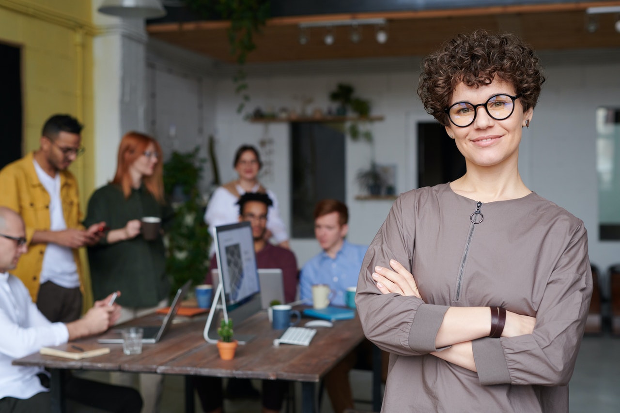 Woman standing in front of coworkers at insurance agency