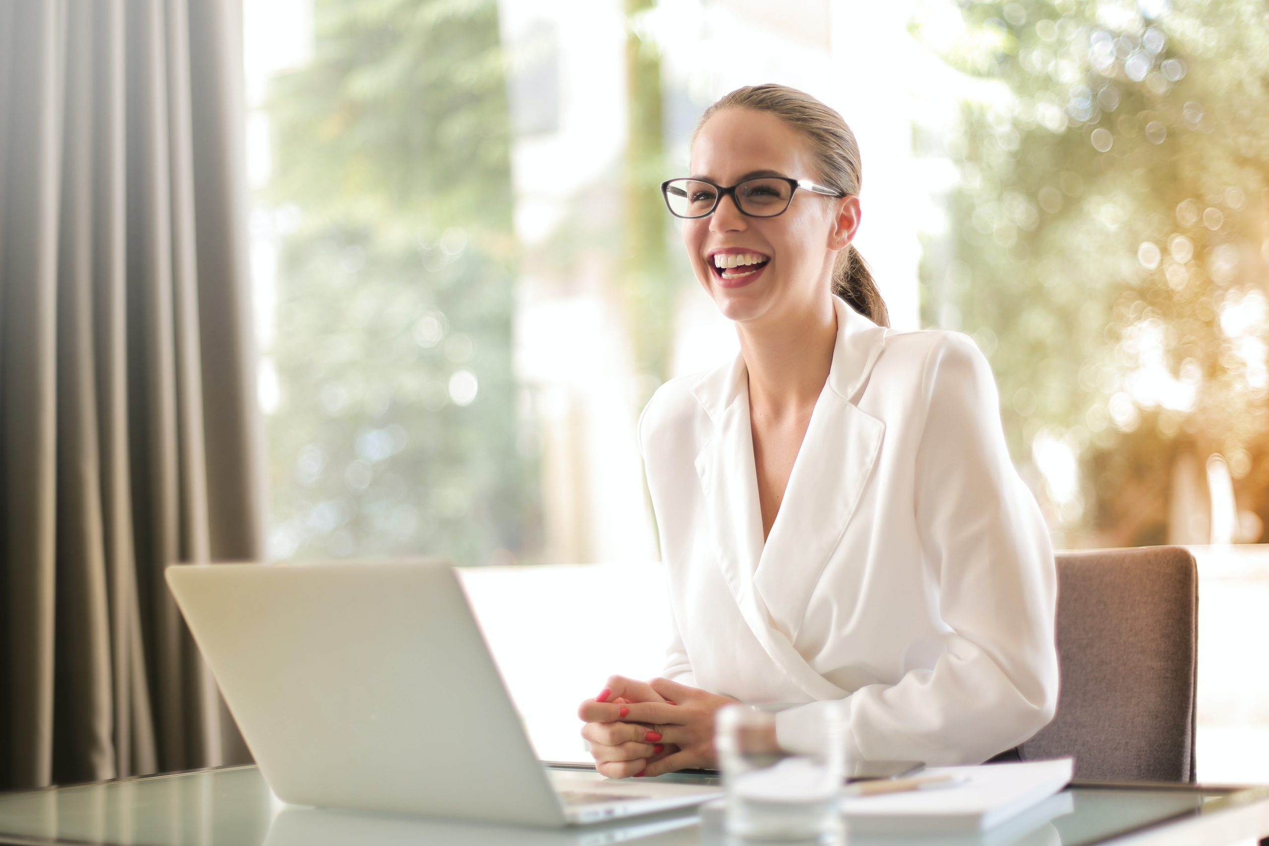 Woman laughing at computer because she will start working in the insurance industry