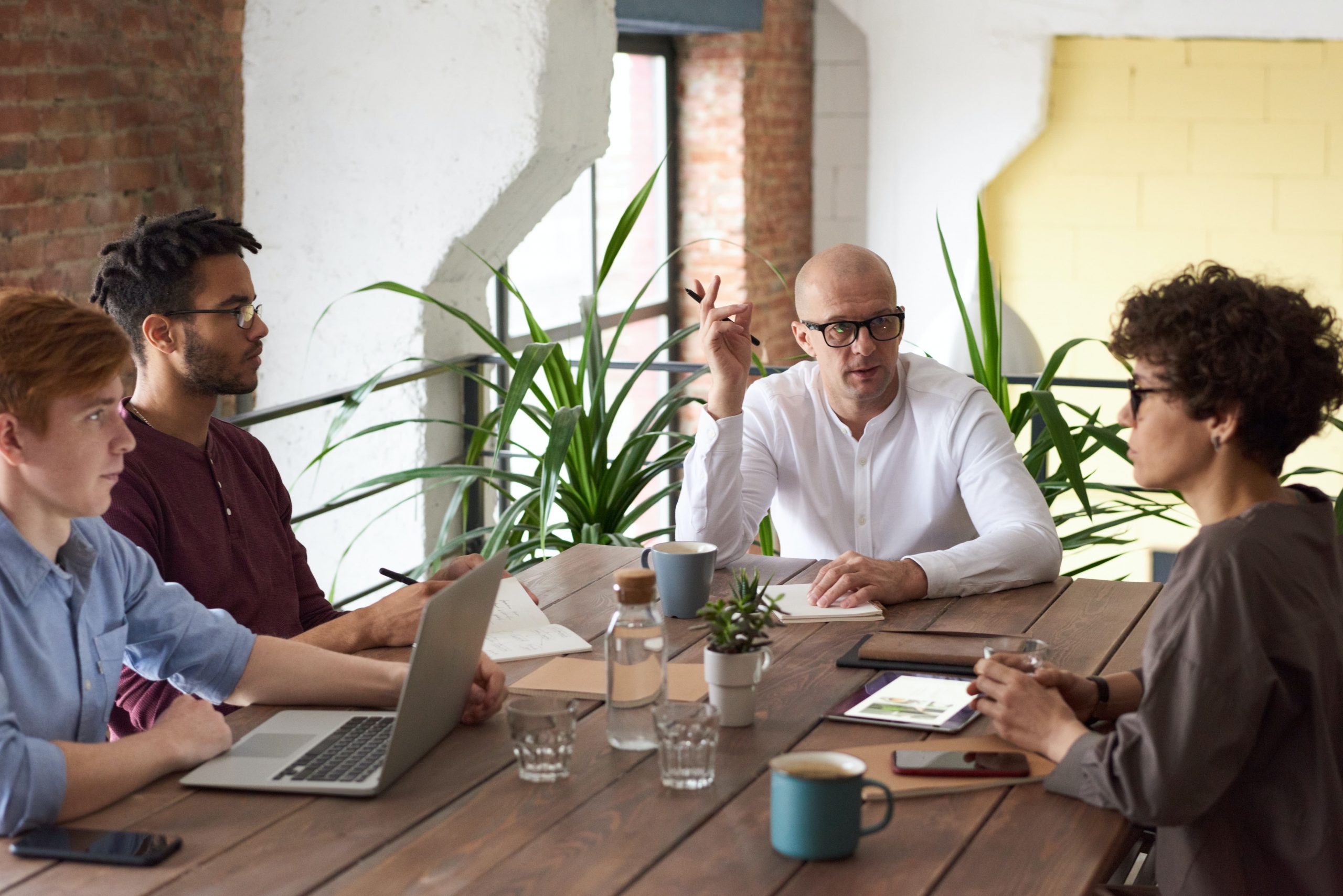 Three men and a woman having a meeting at their insurance agency