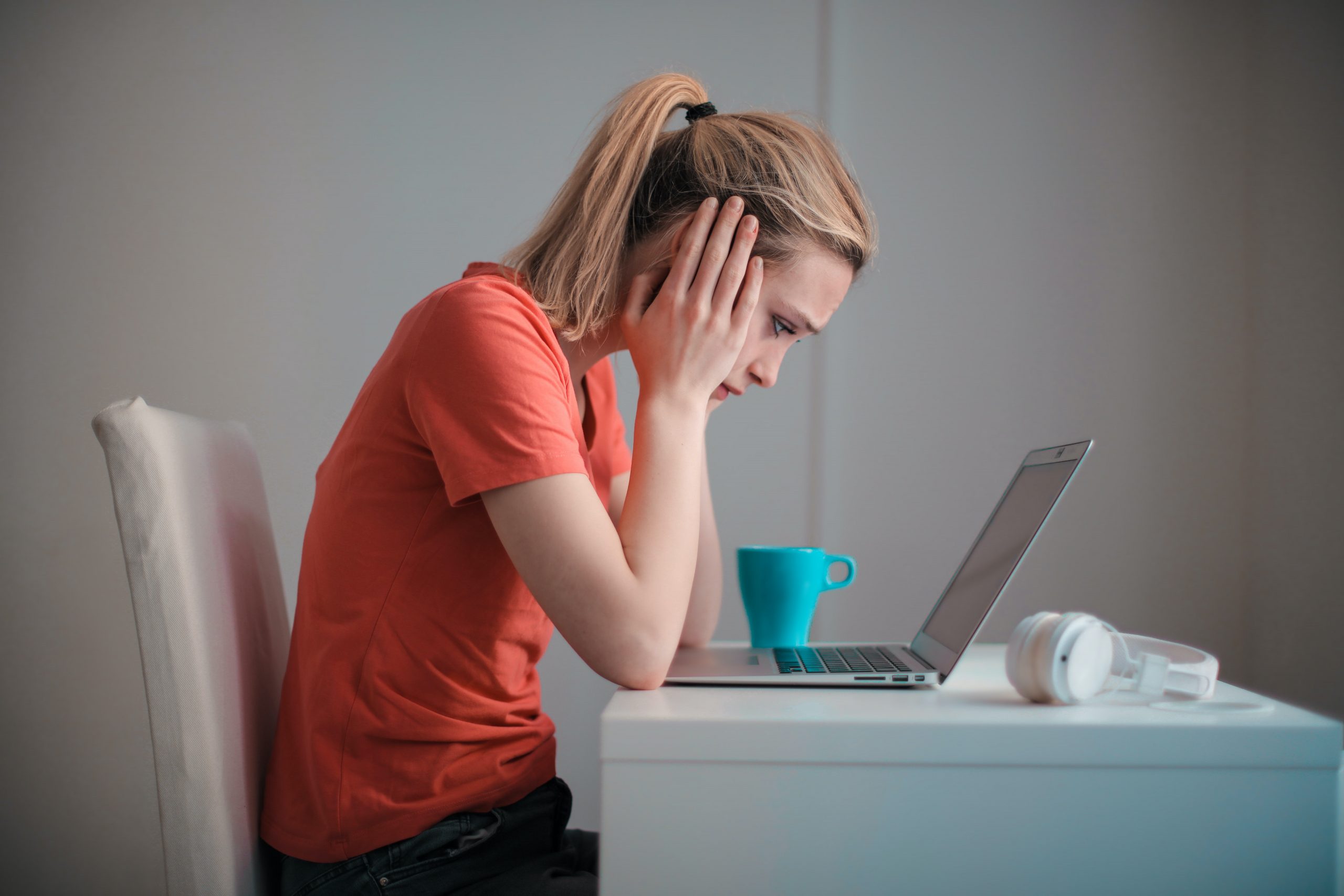 Woman at Laptop Computer Holding Head in Hands