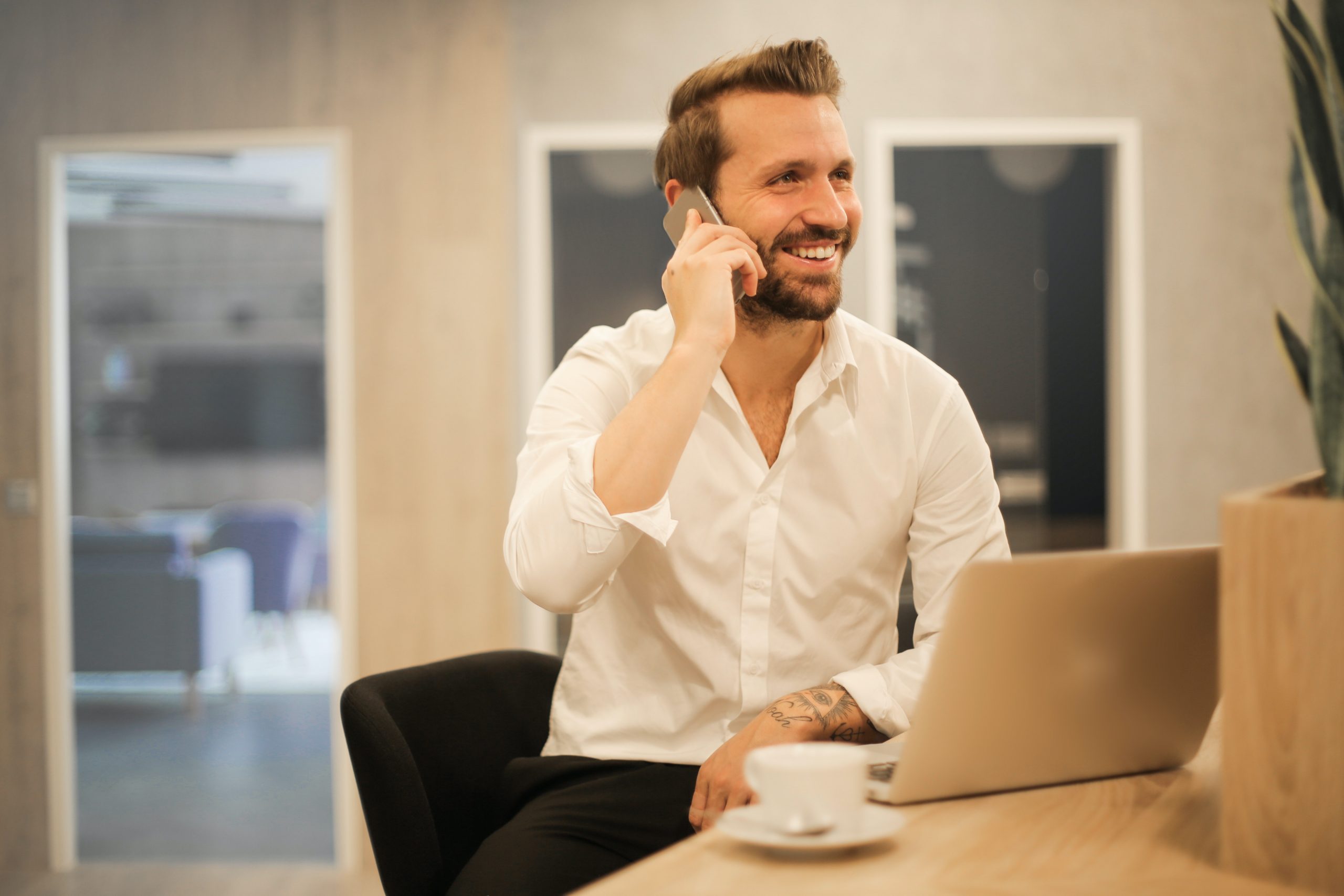 Professional Man on Laptop Making a Phone Call about His New Designations