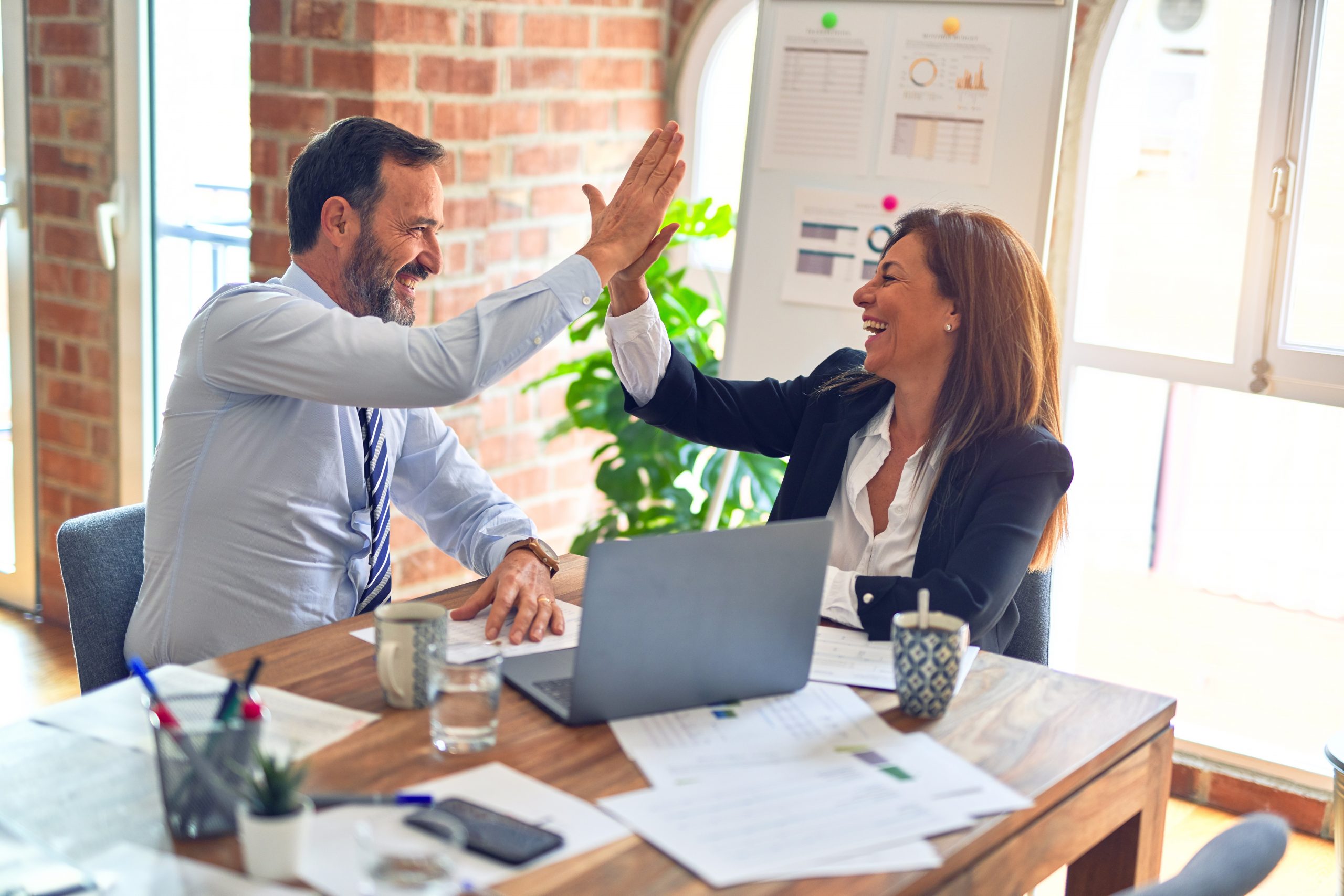 Manager and Employee at Insurance Agency High Fiving