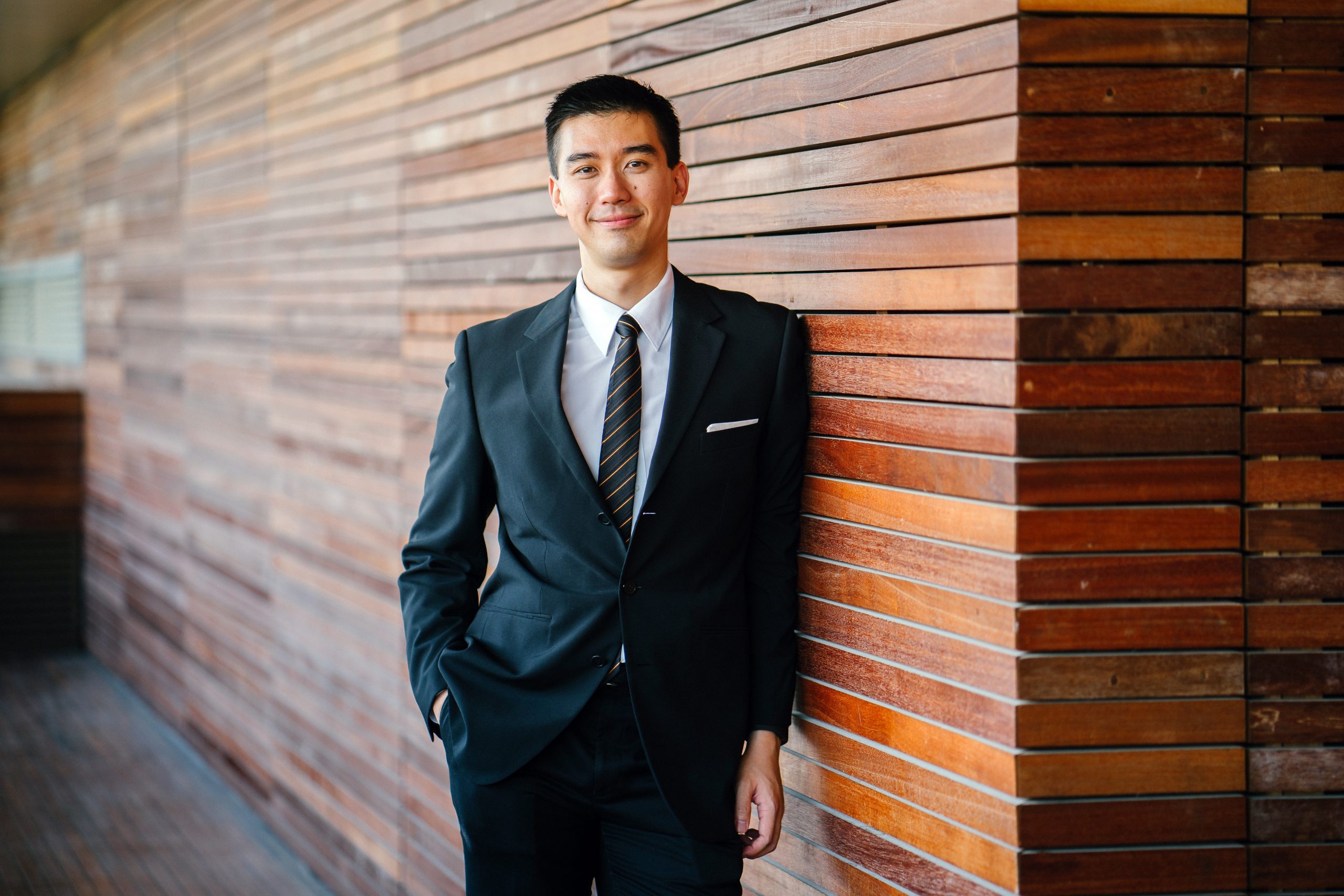 Businessman Leaning on Wall Wearing a Suit and Tie