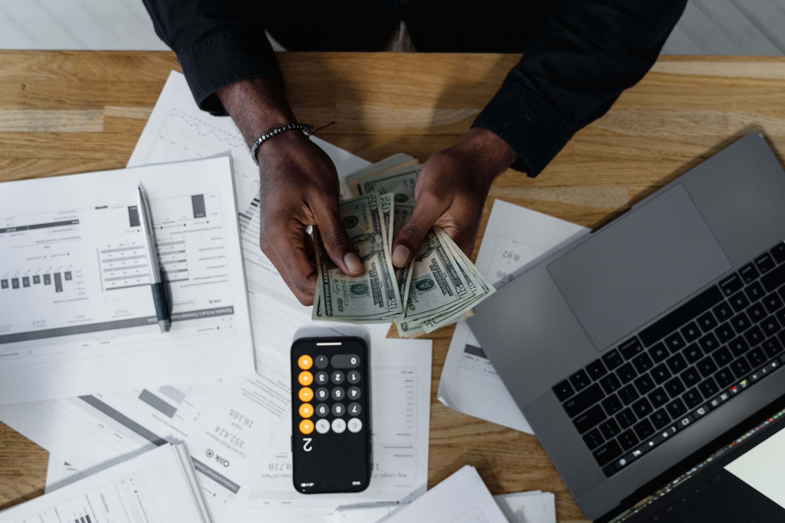 Insurance Agency Owner Calculates Financial Statements with Calculator on Desk